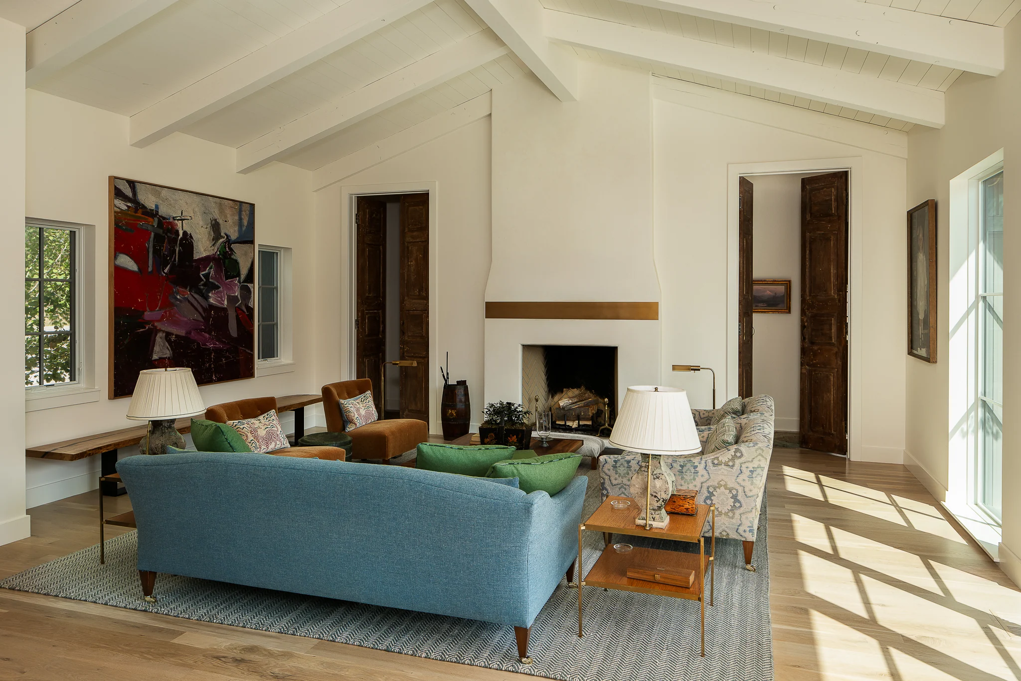 Living room with vaulted wood-beam ceiling and a blue sofa — interior design photography Driggs Idaho, WTG Architects